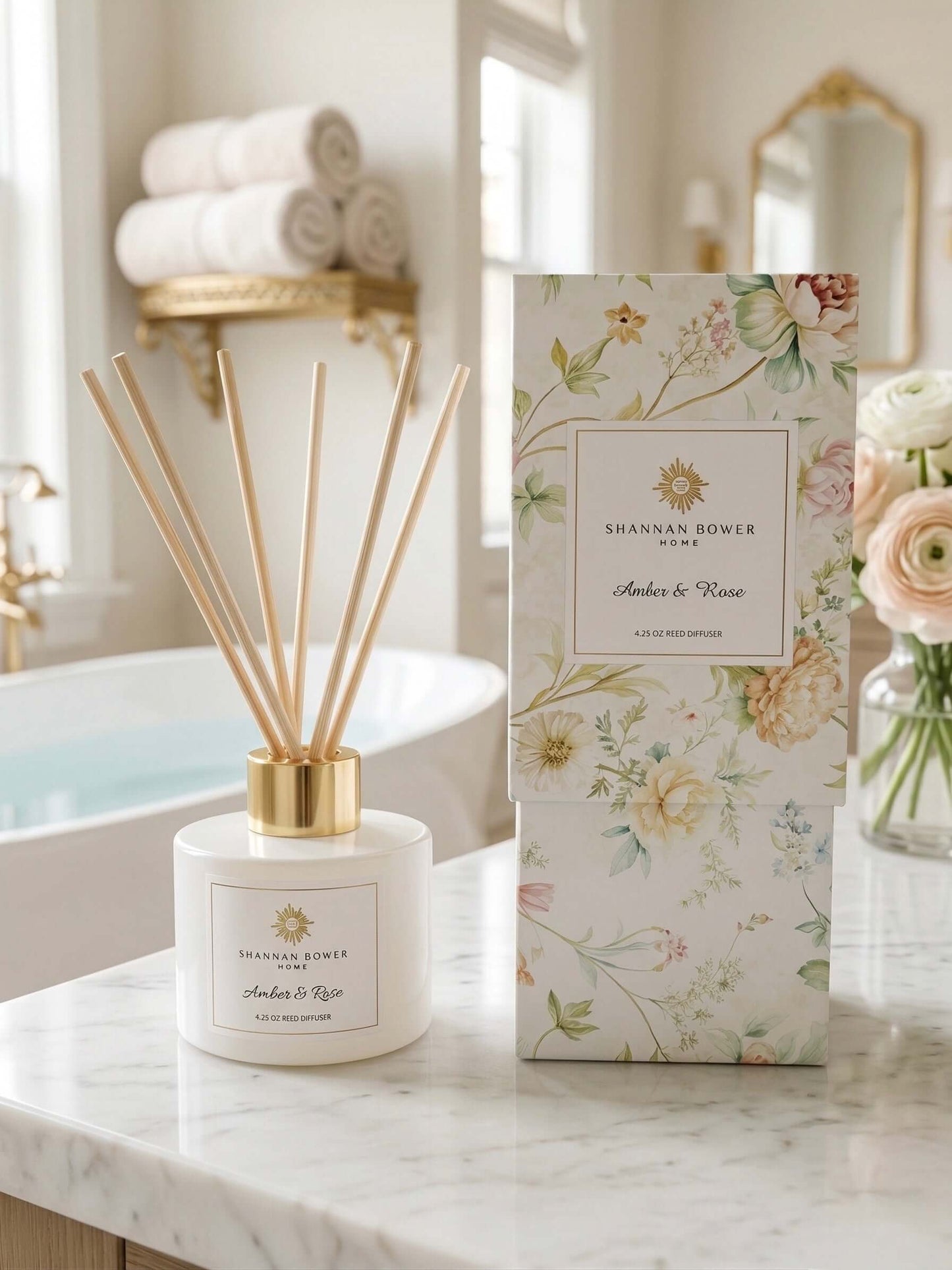 Amber & Rose Reed Diffuser sitting aside packaging on a beautiful marble countertop in luxurious bathroom.