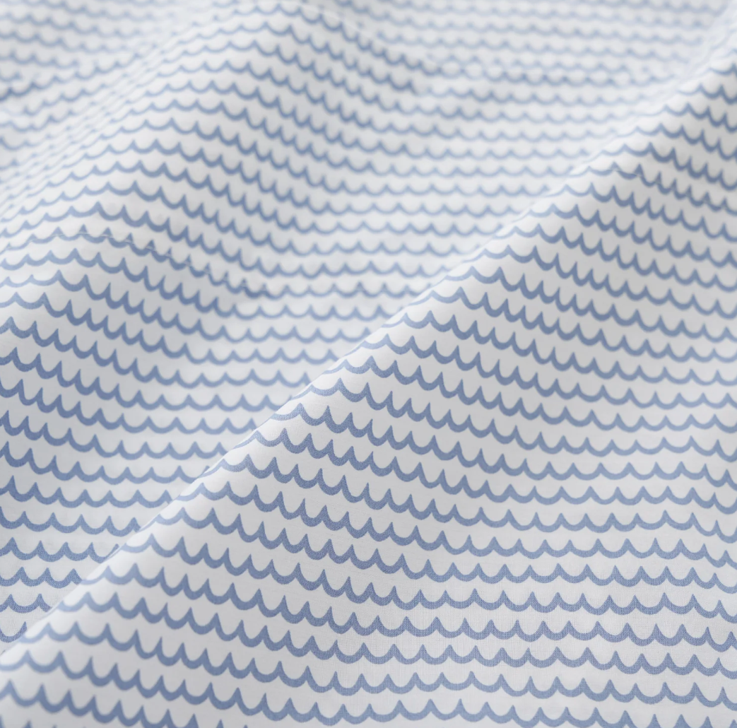 white percale sheet sets with blue stripes on the edges, neatly folded.