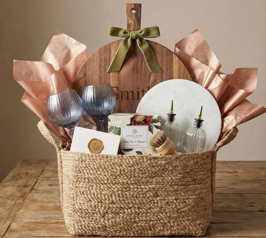 Luxury gift basket with engraved serving board, blue stemware, candles, and curated home gifts for realtor closing or housewarming gifts