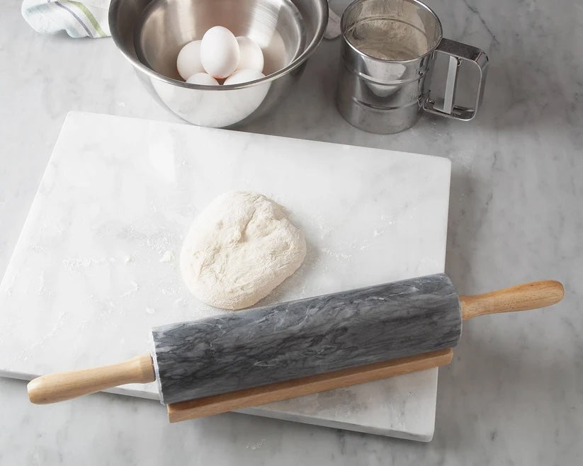 Luxury kitchen styling with marble rolling pin, baking dough, and stainless steel mixing bowls