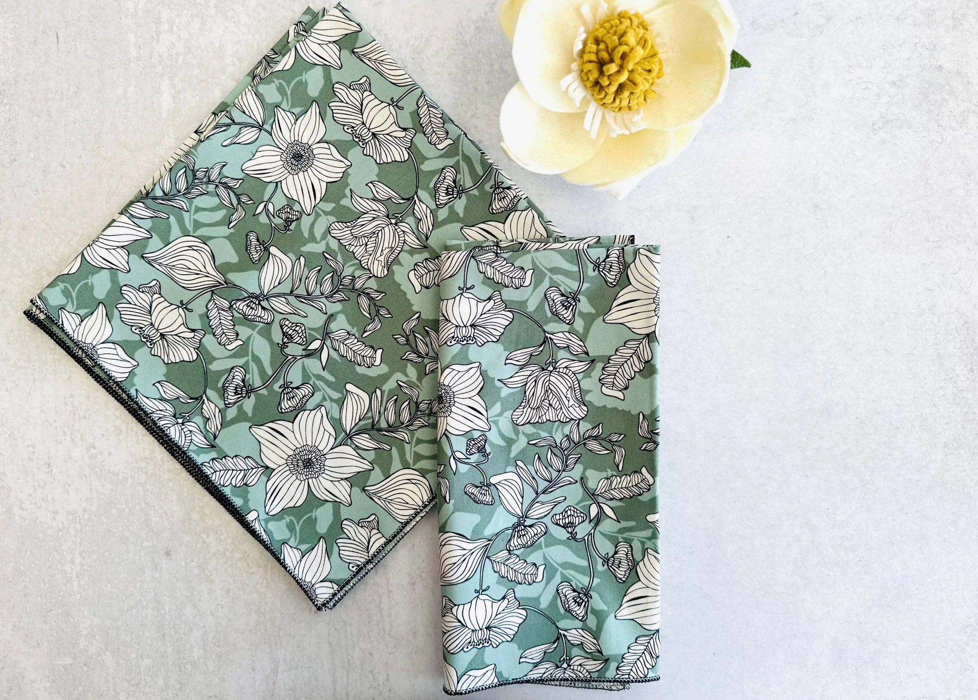 Green floral square napkins with stitched border, three pieces