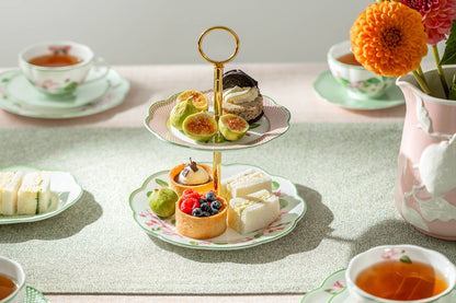 Afternoon tea setup with pastries, fruits, and tea on a table.