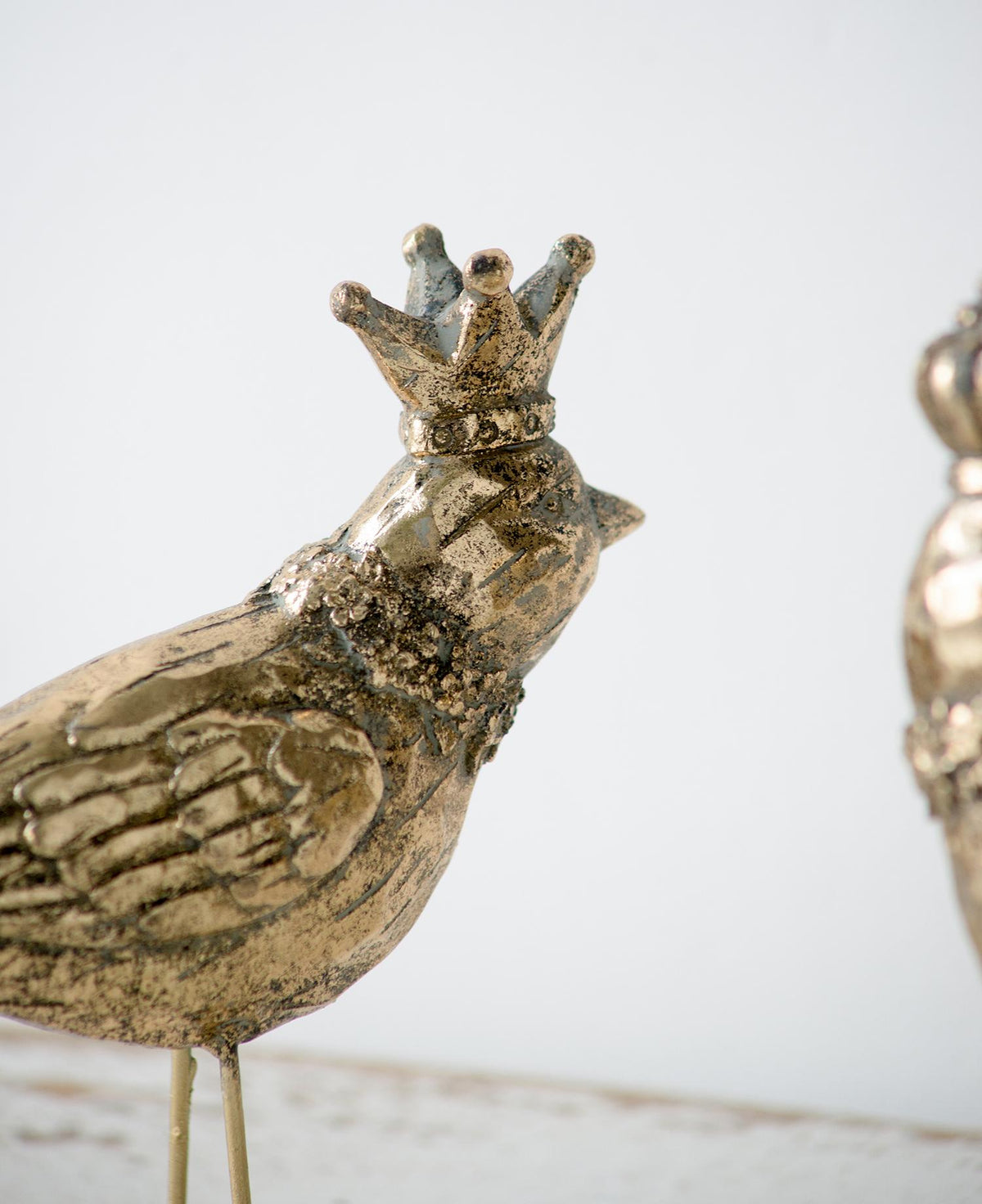 Decorative bird figurine with a crown on a light background