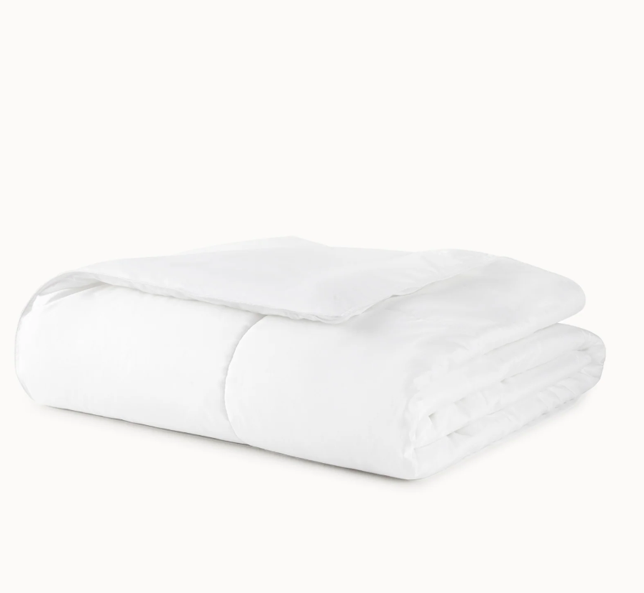 Folded white comforter on a white background