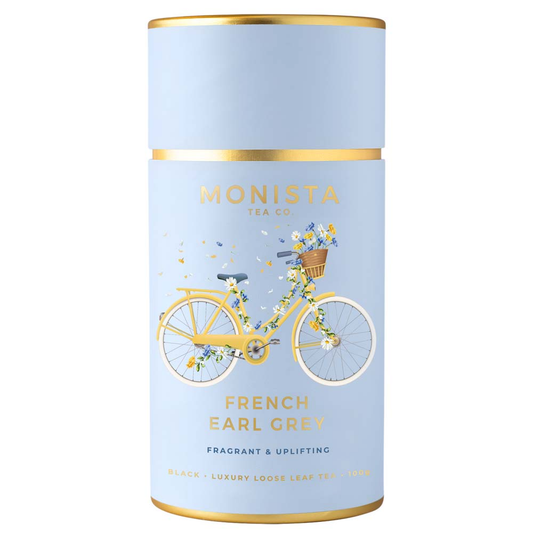 Tea canister with a bicycle illustration and 'Monista Tea Co' branding on a light blue background.