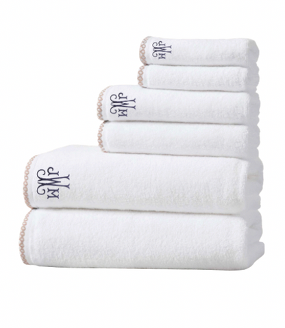 Set of white towels with a monogram on a white background