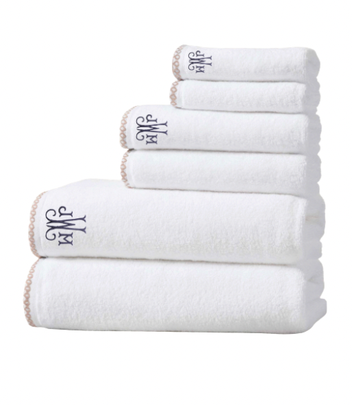 Set of white towels with a monogram on a white background