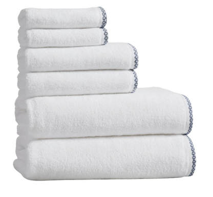 Stack of white towels with a chain detail on a white background