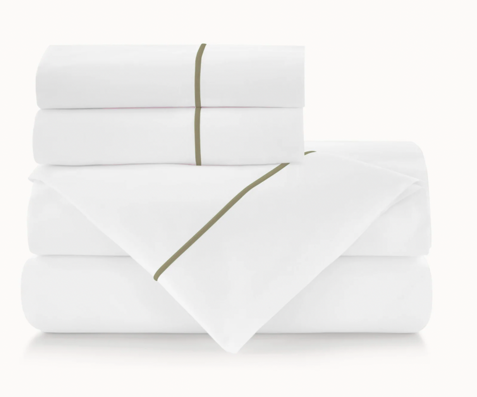Folded white bed sheets with a green line on a white background