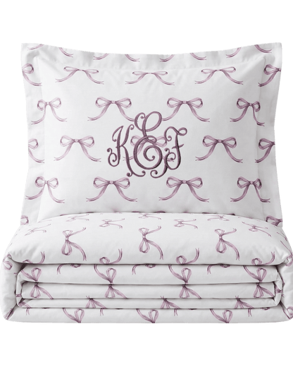 White pillowcase with pink bows and monogram on a white background