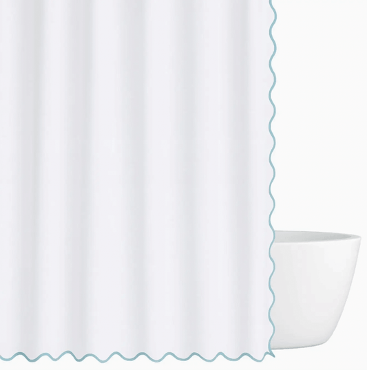 Blue Scalloped Shower Curtain with scalloped edge next to a white bathtub.