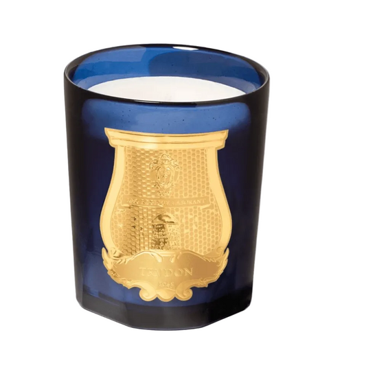 Trudon Madurai Candle in a blue glass holder with gold emblem displayed on a white background.