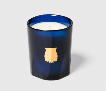 Trudon Madurai Candle in a blue glass holder with a white candle inside, displayed on a light gray background.