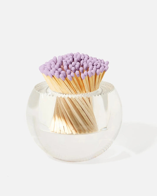 A clear round Match Holder with Striker container holding a bundle of wooden matchsticks with light purple tips, photographed on a clean white background.