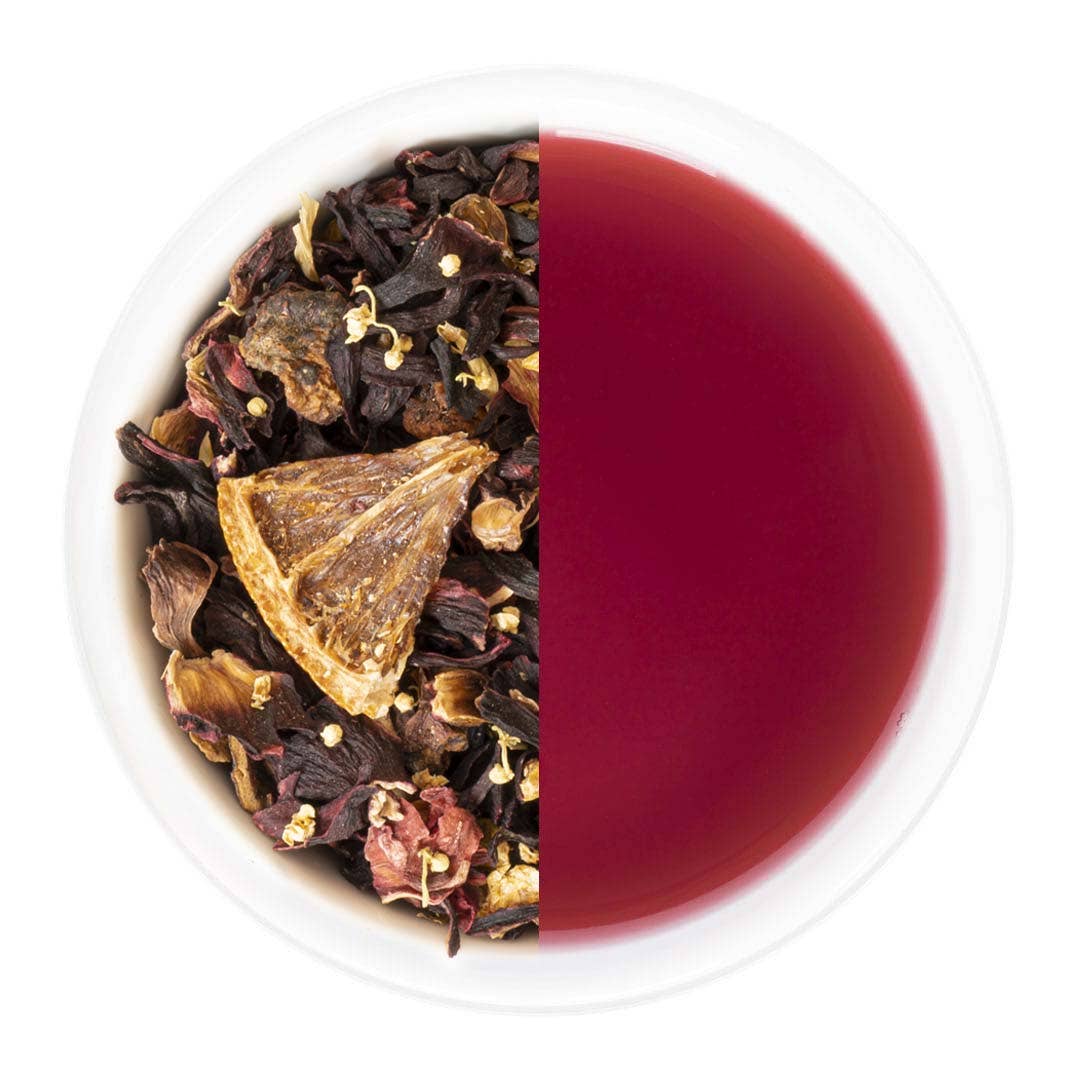 Tea leaves on one side and brewed tea on the other in a divided bowl.
