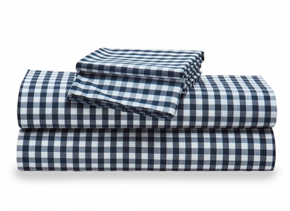 A stack of white percale sheet sets with blue stripes on the edges, neatly folded.