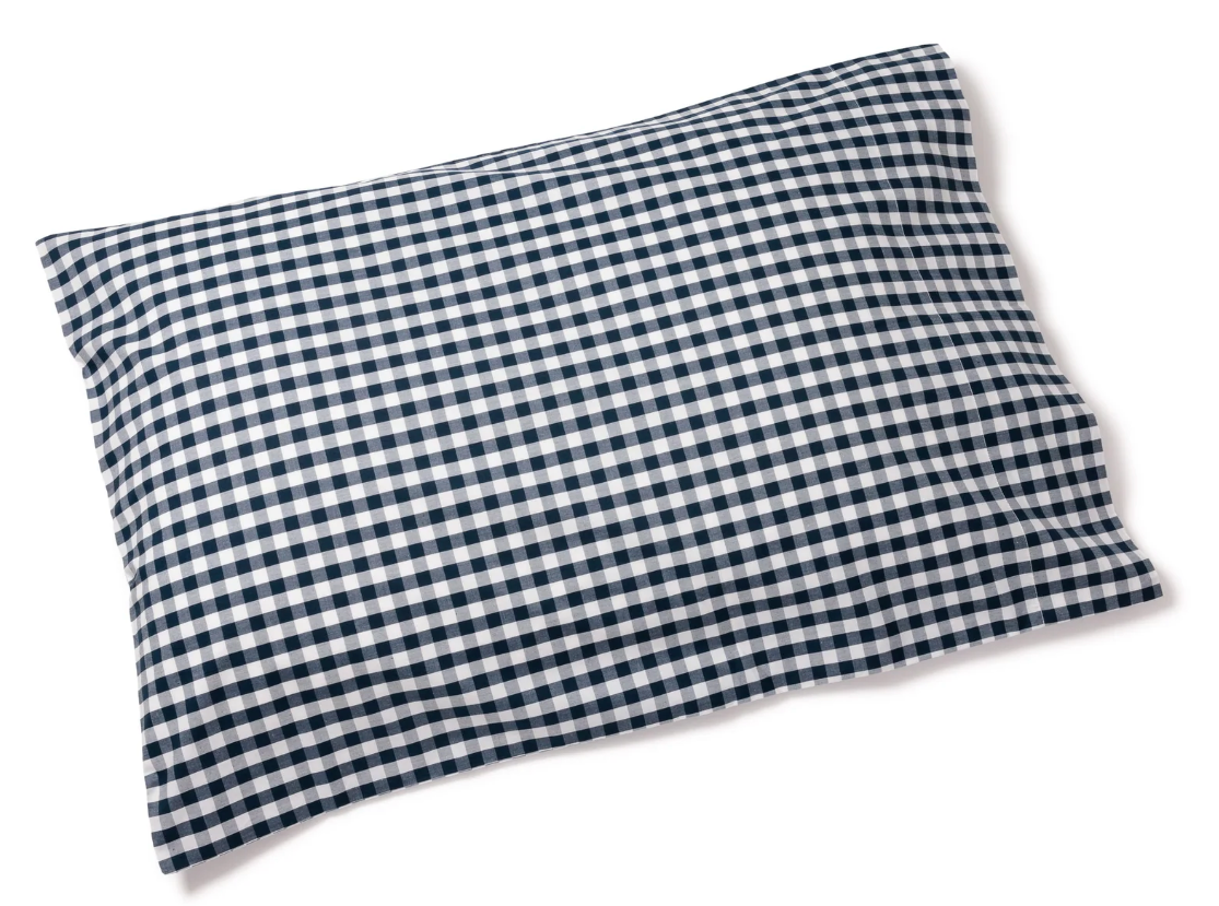 A stack of white percale sheet sets with blue stripes on the edges, neatly folded.