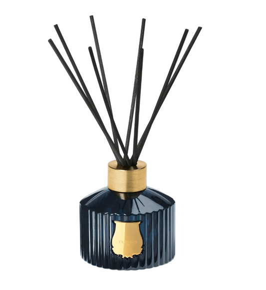 Trudon Reggio Reed Diffuser in a handcrafted blue glass jar with black reeds and a gold aluminum ring.