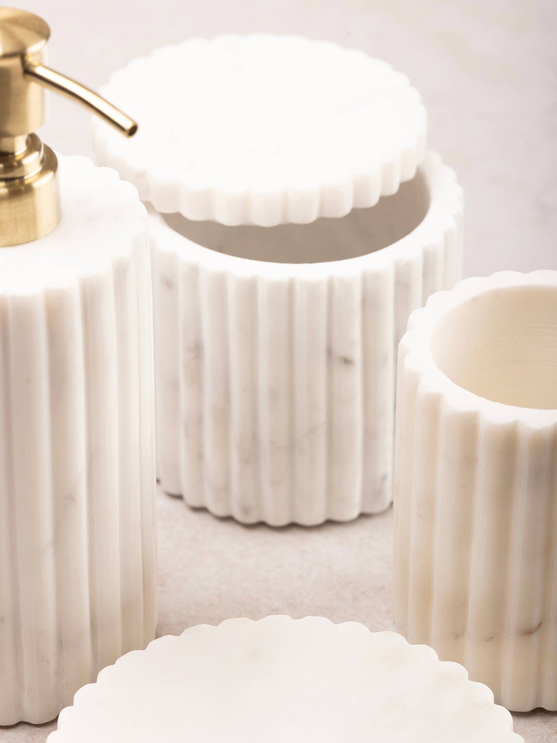 Fluted white marble bath accessory holders with scalloped, ridged design