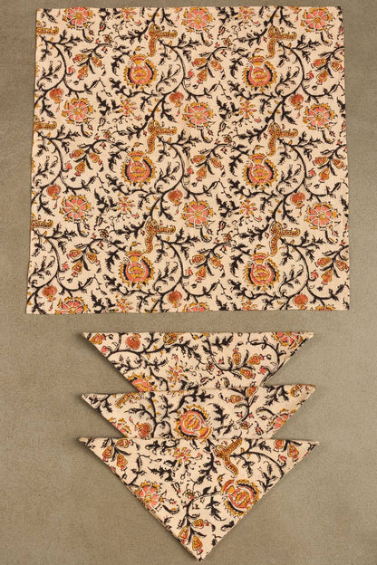 Light cream dinner napkin with ornate rose and paisley pattern, folded flat