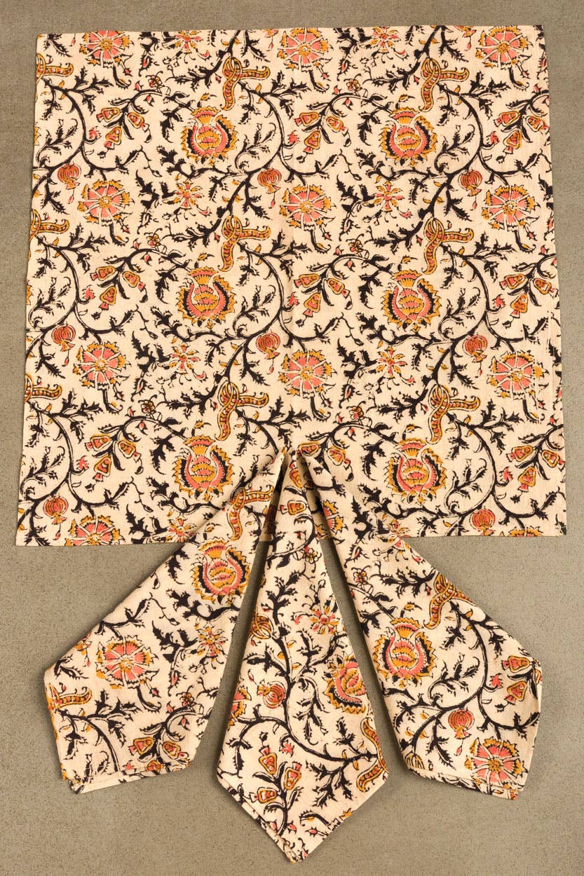 Light cream dinner napkin with ornate rose print, square top with folded wedge pieces