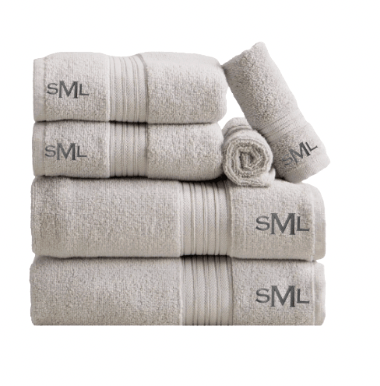 Monogrammed dorm bath bundle — set of folded beige bath, hand, and wash towels with embroidered monogram