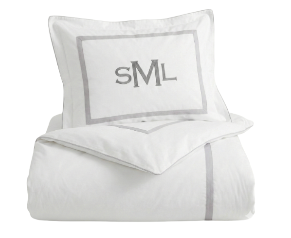White bedding set with gray trim and monogram on a white background