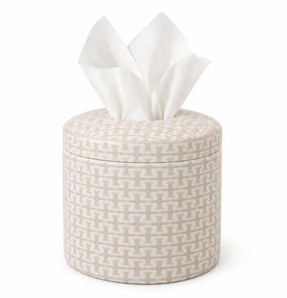 A cylindrical tissue box cover with a woven geometric pattern in beige and white, shown with white tissue paper protruding from the top on a clean white background.