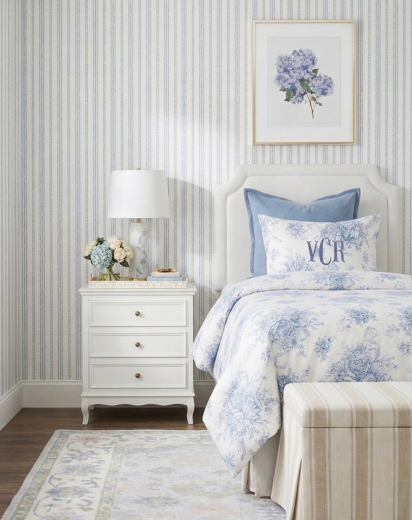 Bedroom with floral bedding, nightstand, and striped wallpaper