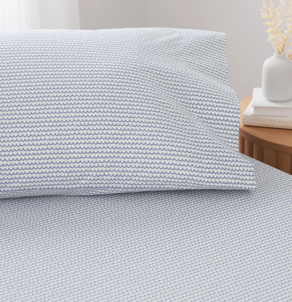  white percale sheet sets with blue stripes on the edges, neatly folded.