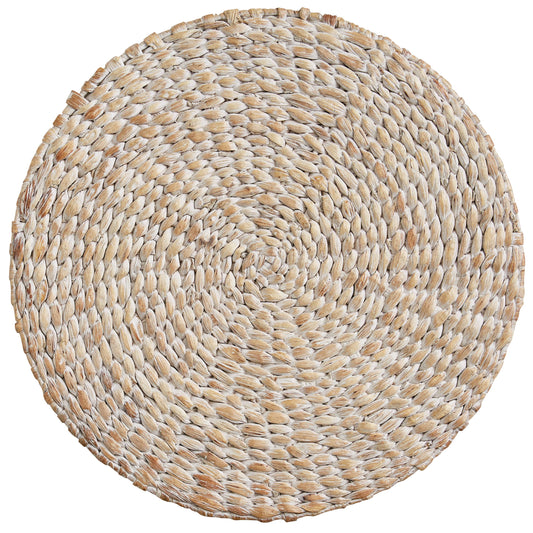 A round placemat made from braided natural water hyacinth.