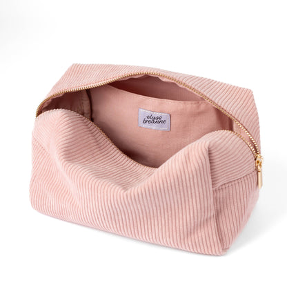 Rose pink corduroy cosmetic bag with open top, fabric lining, and logo label